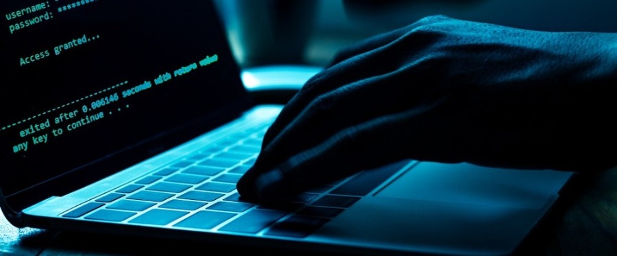 Fraudster typing on laptop